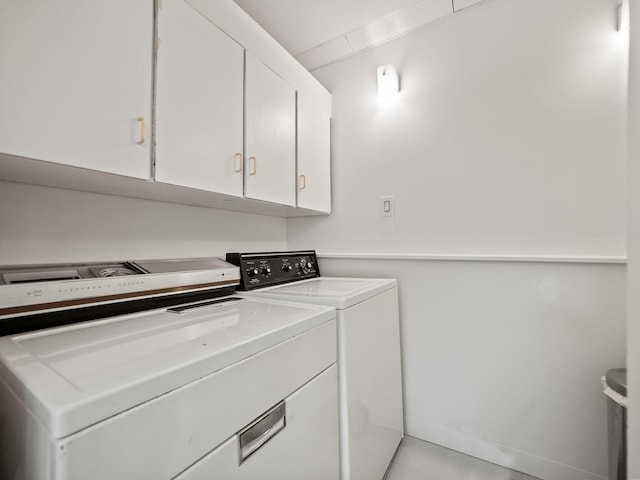 laundry area with cabinet space, light tile patterned flooring, and washing machine and dryer