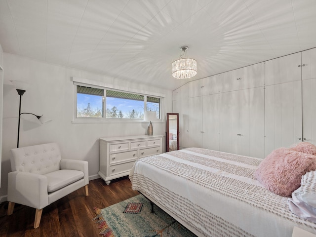 bedroom with an inviting chandelier, baseboards, and dark wood-style flooring