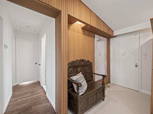 corridor with baseboards and attic access