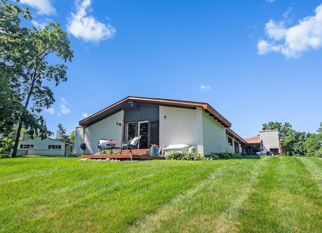 2330 N Pine Center Dr, West Bloomfield, MI 48323 - rear view of house with brick siding, a wooden deck, and a yard