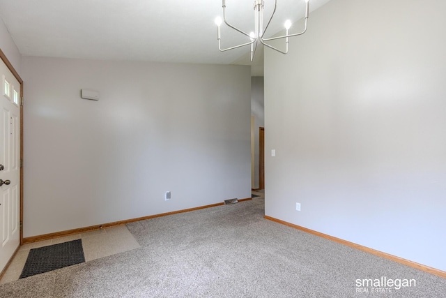 empty room featuring baseboards, carpet, and a notable chandelier