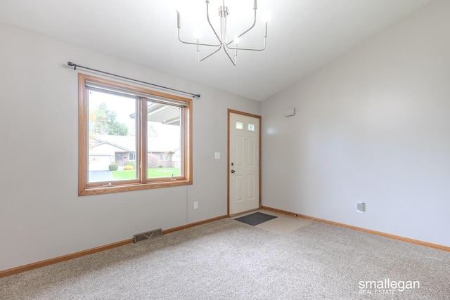 carpeted entryway featuring baseboards, visible vents, and an inviting chandelier