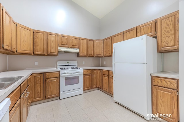 kitchen with brown cabinets, white appliances, light countertops, high vaulted ceiling, and under cabinet range hood