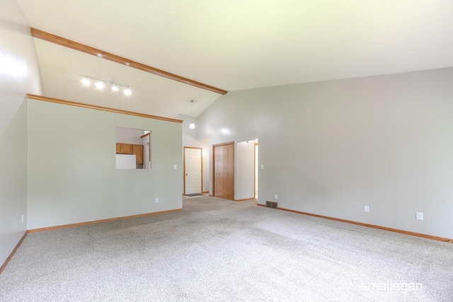 spare room featuring beamed ceiling, baseboards, and carpet