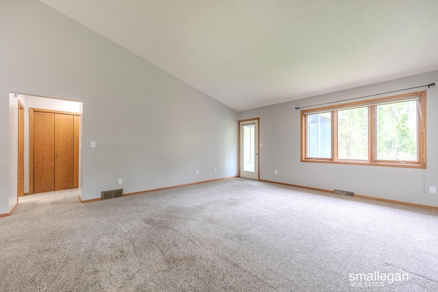 unfurnished room featuring baseboards, light colored carpet, high vaulted ceiling, and visible vents