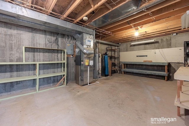 unfinished below grade area featuring heating unit and gas water heater