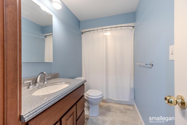 full bathroom with vanity, baseboards, and toilet
