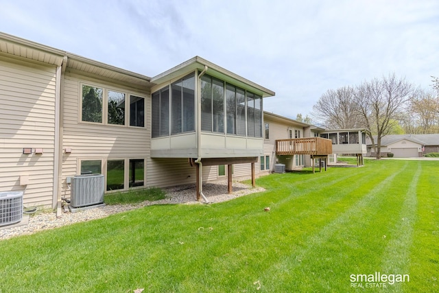 back of house featuring a yard, a sunroom, and central AC
