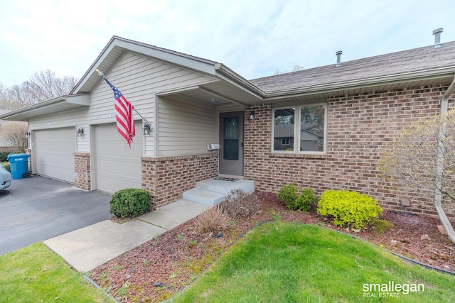 view of front of home with brick siding, an attached garage, driveway, and entry steps