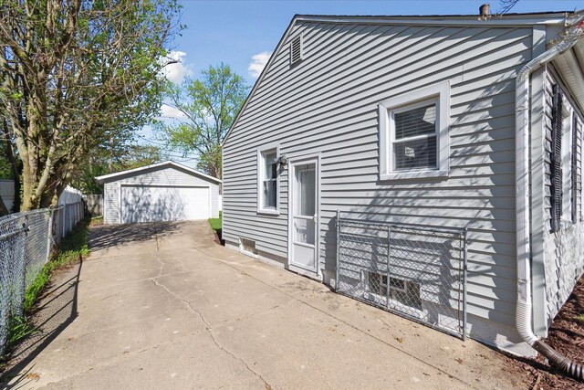 view of side of home featuring fence, an outdoor structure, and a garage
