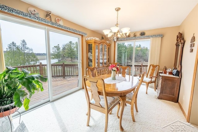4438 N Verity Rd, Sanford, MI 48657 - dining room featuring light colored carpet, a water view, and a chandelier