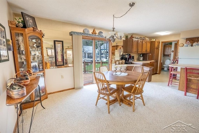 4438 N Verity Rd, Sanford, MI 48657 - dining space with light colored carpet, baseboards, and a notable chandelier