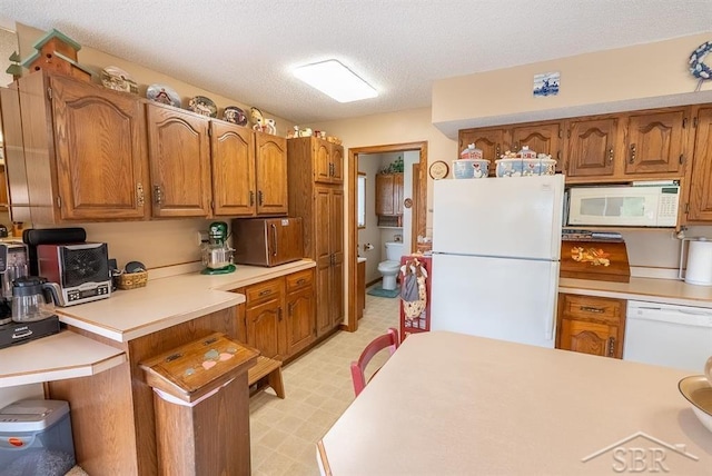 4438 N Verity Rd, Sanford, MI 48657 - kitchen with white appliances, brown cabinetry, and light countertops