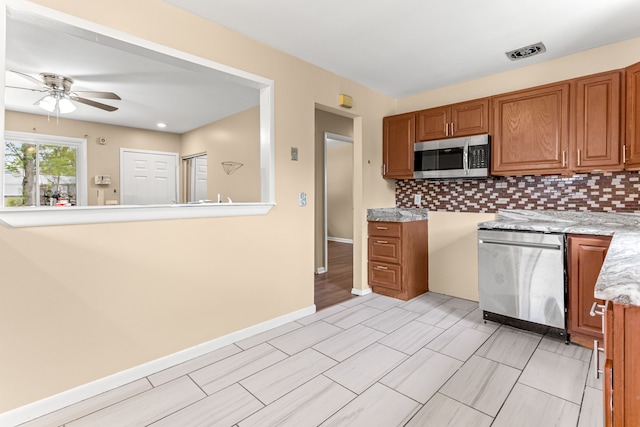 kitchen featuring ceiling fan, brown cabinetry, stainless steel appliances, and visible vents