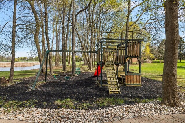 view of jungle gym featuring a lawn and a water view