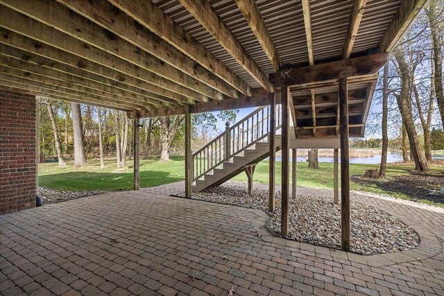 view of patio / terrace featuring stairs and a water view