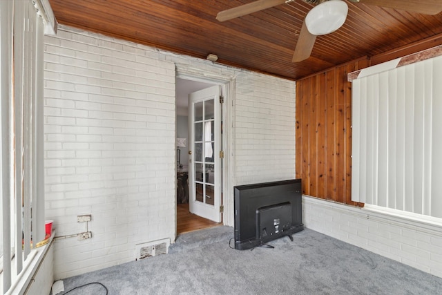 17172 Huntington Rd, Detroit, MI 48219 - unfurnished living room with ceiling fan, a wood stove, carpet, wooden ceiling, and visible vents