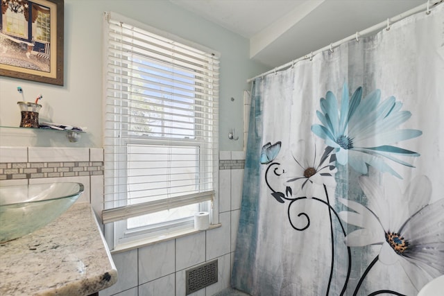 17172 Huntington Rd, Detroit, MI 48219 - bathroom featuring tile walls, a wealth of natural light, a shower with shower curtain, and visible vents