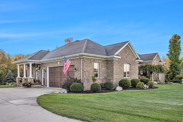 view of front of home with a front yard, a garage, brick siding, concrete driveway, and a shingled roof