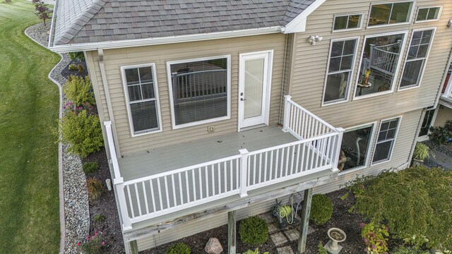 exterior space with a downspout, gutters, and roof with shingles