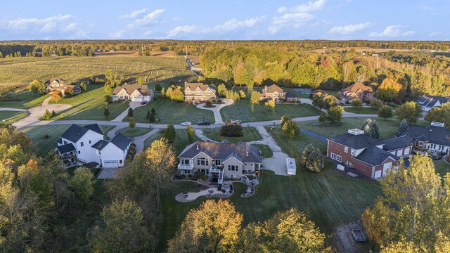 drone / aerial view featuring a residential view and a wooded view