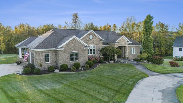 view of front of house featuring stone siding, brick siding, and a front yard