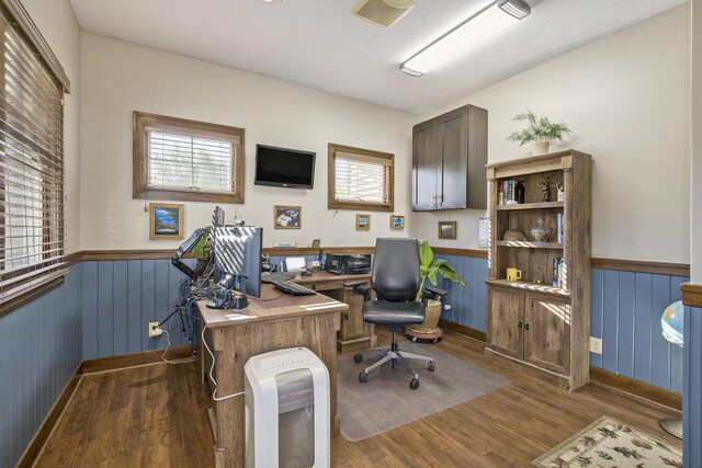 office space featuring wood walls, wainscoting, and wood finished floors