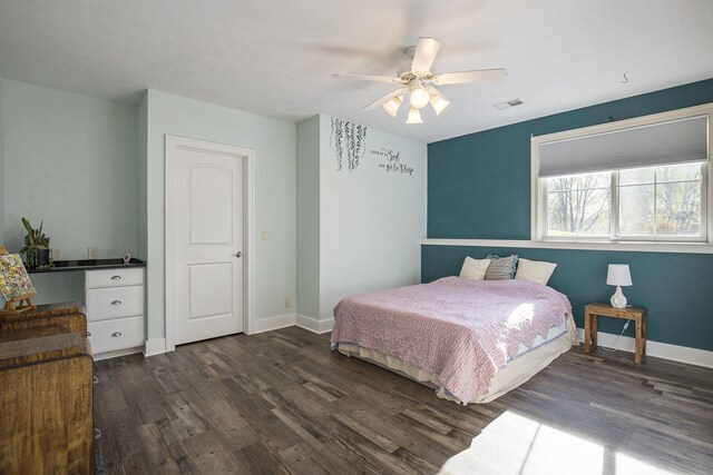 bedroom with baseboards, visible vents, dark wood-style floors, and ceiling fan