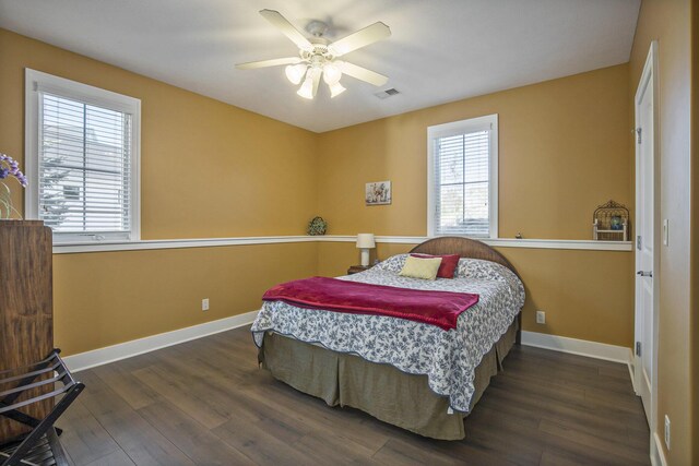 bedroom with baseboards, a ceiling fan, wood finished floors, and visible vents