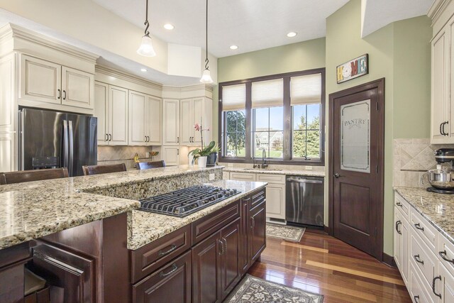 kitchen with backsplash, stainless steel appliances, light stone counters, and dark wood finished floors