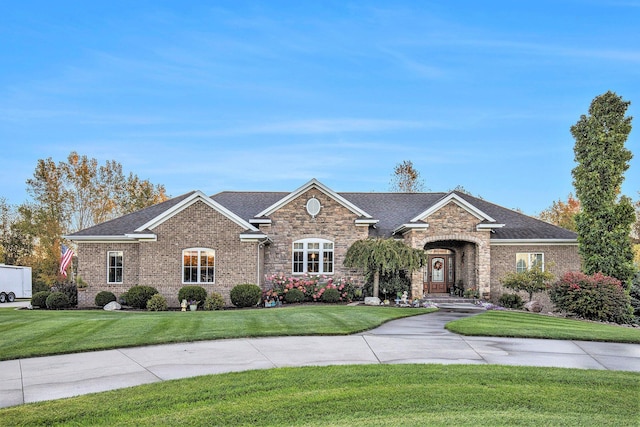 ranch-style house with brick siding, roof with shingles, and a front lawn