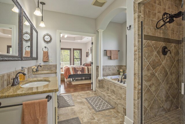 ensuite bathroom featuring a sink, a stall shower, ensuite bath, and a bath