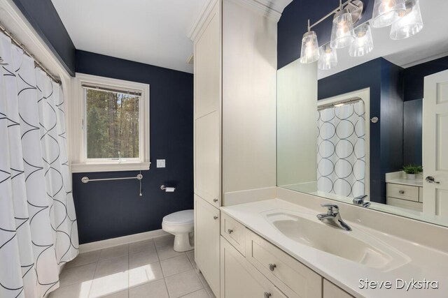 bathroom with tile patterned flooring, baseboards, toilet, and vanity