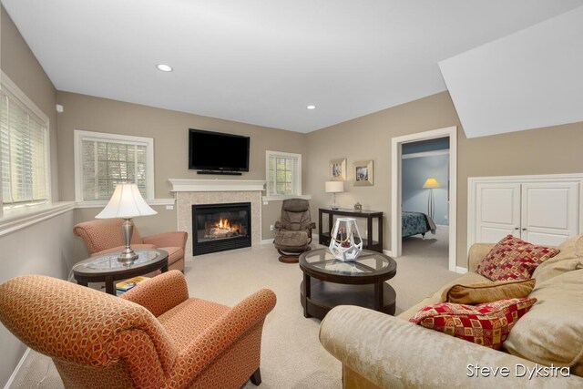 living area with carpet floors, recessed lighting, baseboards, and a tiled fireplace