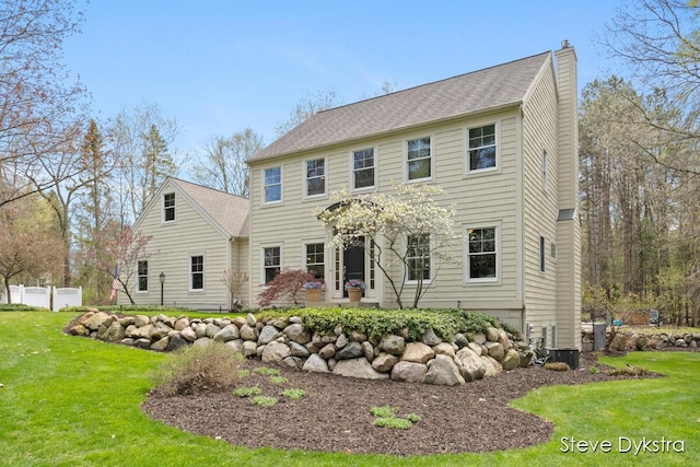 view of front of house with a front lawn, a patio area, fence, and a chimney
