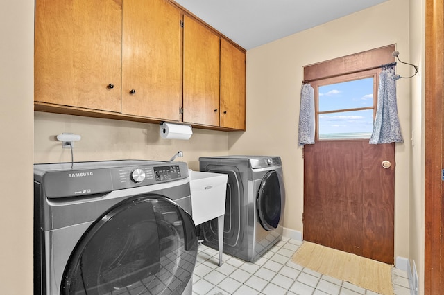 3529 E Lemon Creek Rd, Berrien Springs, MI 49103 - laundry room with washer and clothes dryer, cabinet space, light tile patterned floors, and baseboards