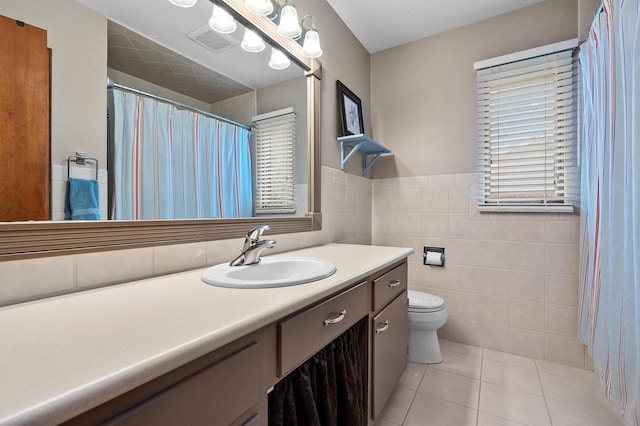 3529 E Lemon Creek Rd, Berrien Springs, MI 49103 - bathroom with tile patterned floors, toilet, vanity, tile walls, and a wainscoted wall