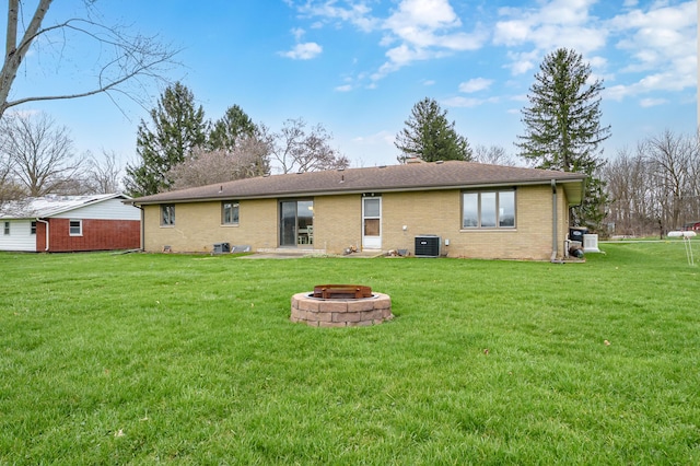 3529 E Lemon Creek Rd, Berrien Springs, MI 49103 - back of house featuring an outdoor fire pit, brick siding, a lawn, and central AC