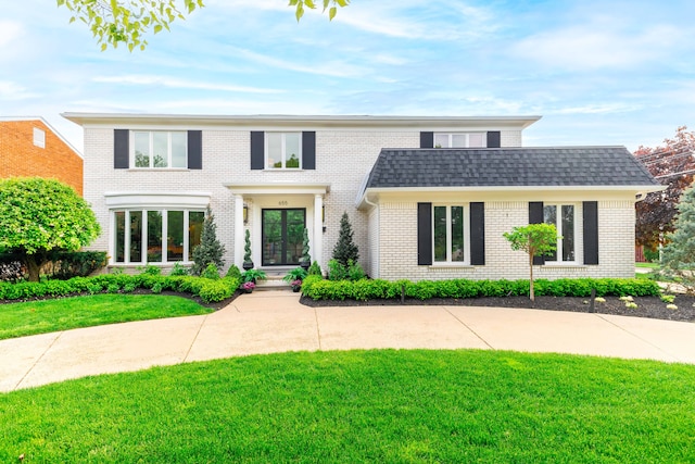 view of front of property with a front lawn, french doors, and brick siding