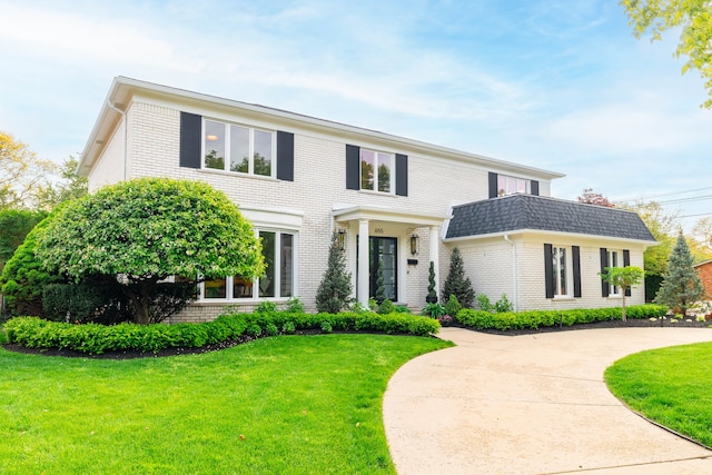 view of front of property featuring brick siding and a front lawn