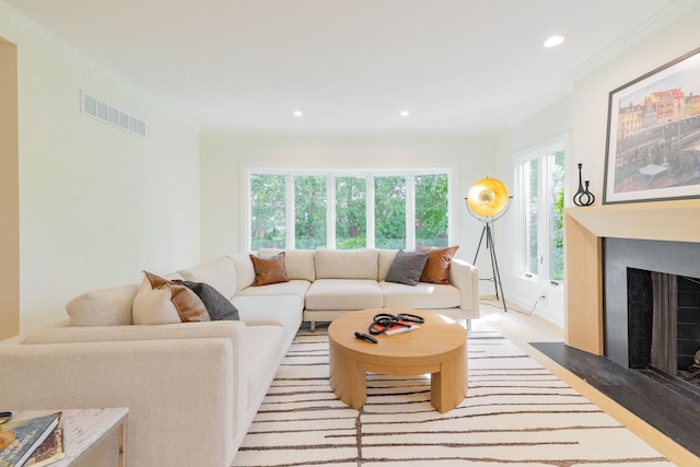 living area featuring ornamental molding, recessed lighting, a fireplace with flush hearth, and light wood-style floors