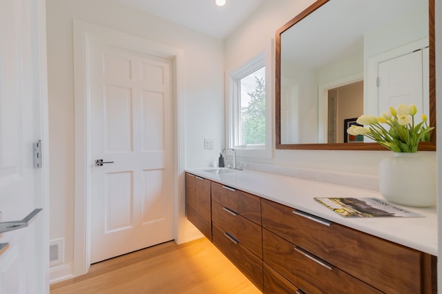 bathroom with wood finished floors, vanity, and recessed lighting