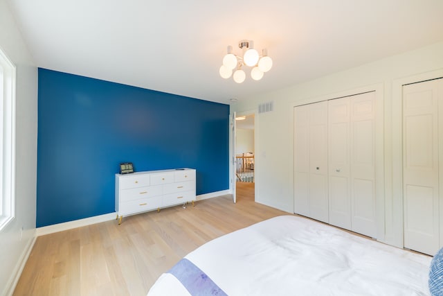 bedroom with wood finished floors, a chandelier, and baseboards