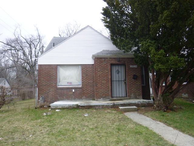 bungalow-style house featuring brick siding, fence, roof with shingles, and a front lawn