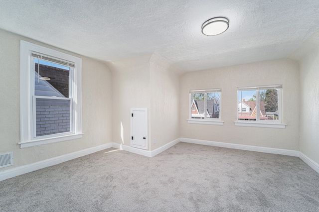 unfurnished room featuring carpet floors, a textured ceiling, and baseboards