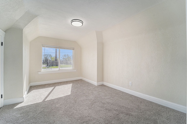 bonus room featuring carpet floors, a textured ceiling, baseboards, and vaulted ceiling