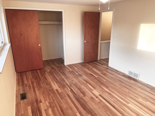 25954 Salem Unit 5, Roseville, MI 48066 - unfurnished bedroom featuring baseboards, visible vents, wood finished floors, and a closet