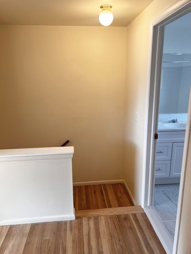 25954 Salem Unit 5, Roseville, MI 48066 - hallway with baseboards, a sink, wood finished floors, and an upstairs landing