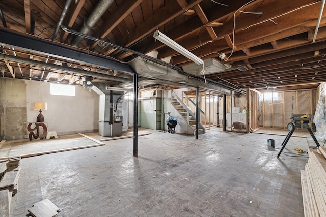 below grade area featuring stairs and heating unit