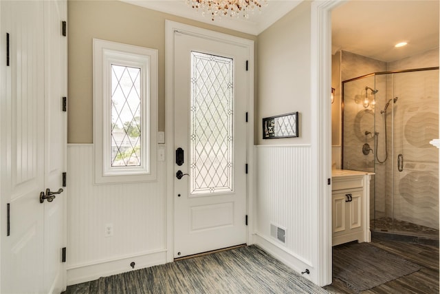 foyer with visible vents, wainscoting, and a decorative wall